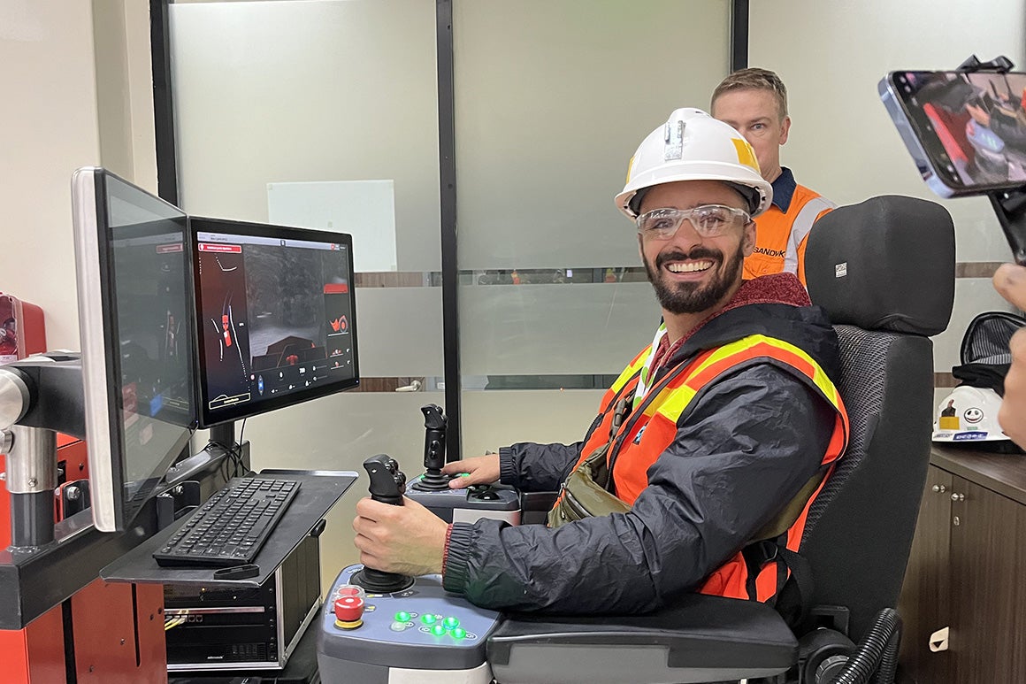 Students wearing construction vests operating a computer