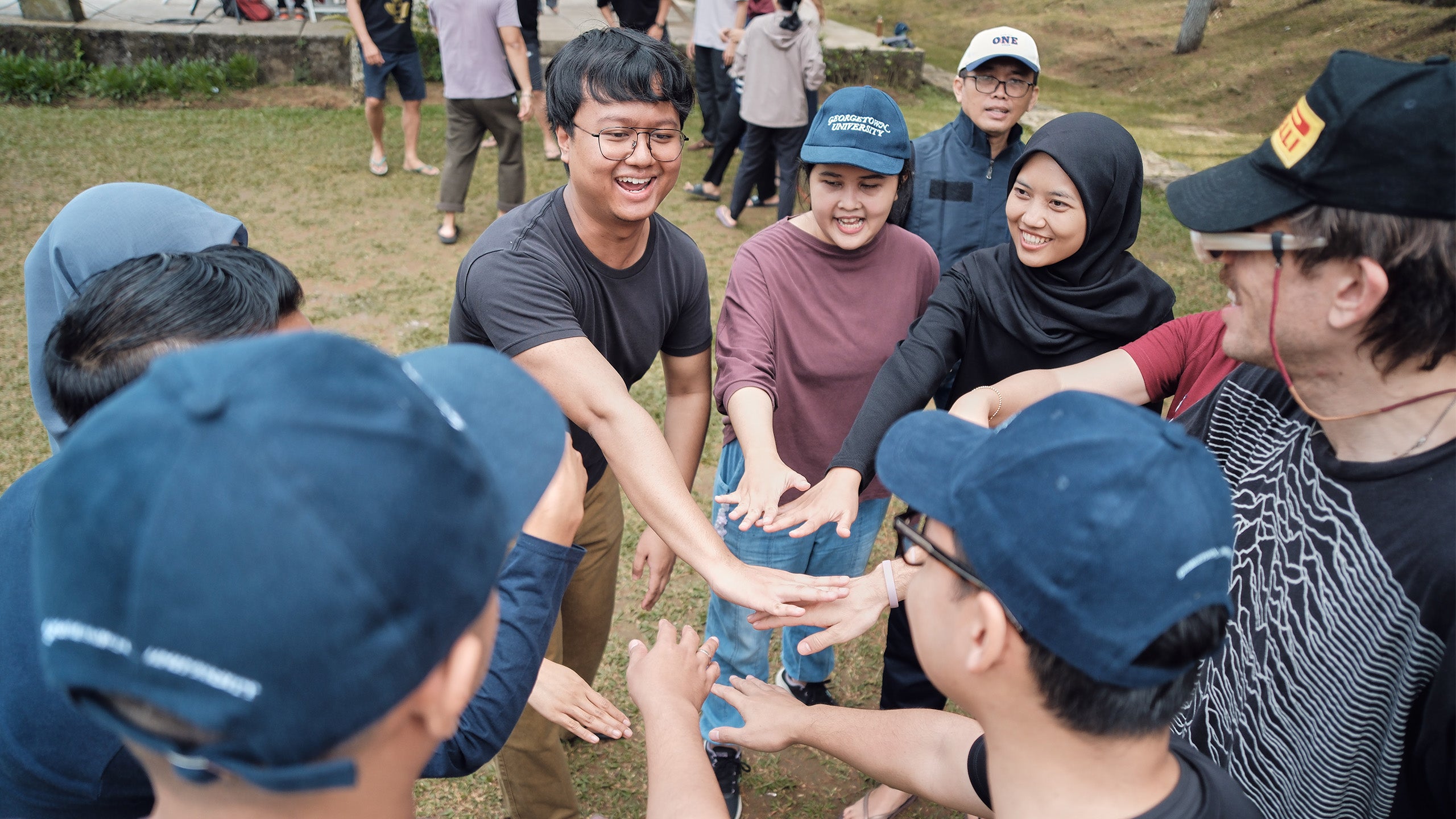 Students shaking hands on a lawn