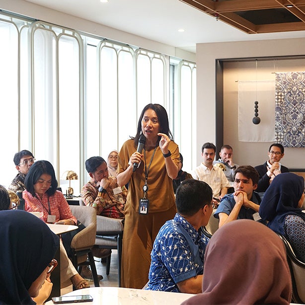A woman giving a presentation to guests in a room