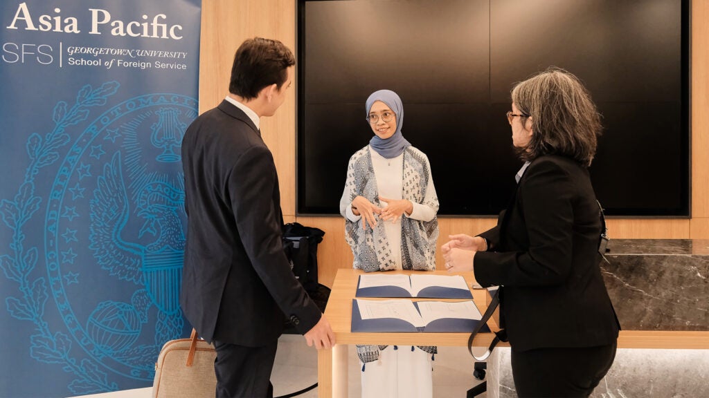 A woman wearing a headscarf talking to other guests