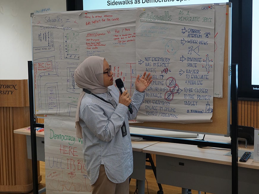 Student in a kerchief present posters