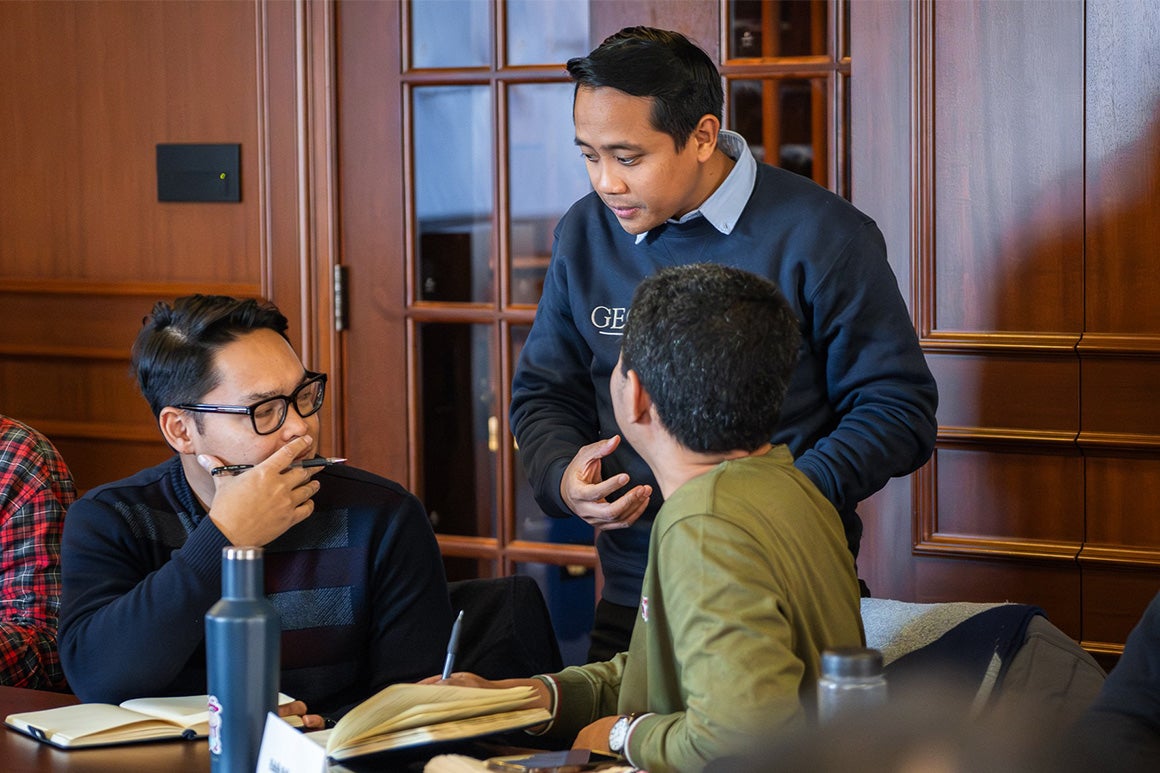 Students studying in a room with a door on the background