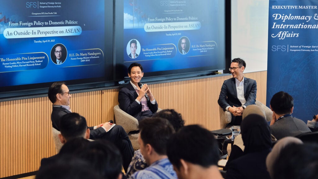 Three speakers giving a panel in front of a classroom